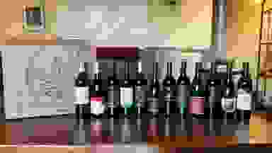 Naked Wines box beside 12 wine bottles beside it on a wooden table.
