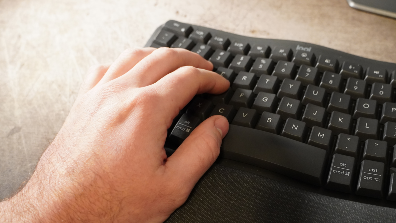 A hand typing on the keyboard.