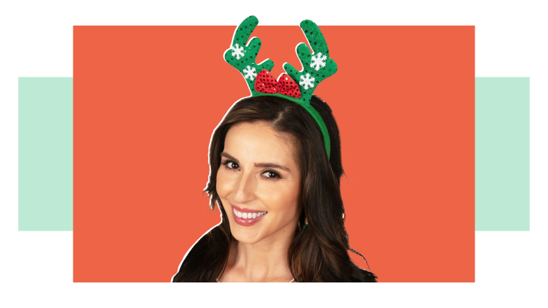 A woman with a green reindeer headband.