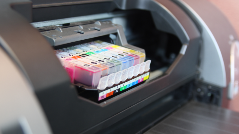 Stock image of an open printer with ink cartridges showing.