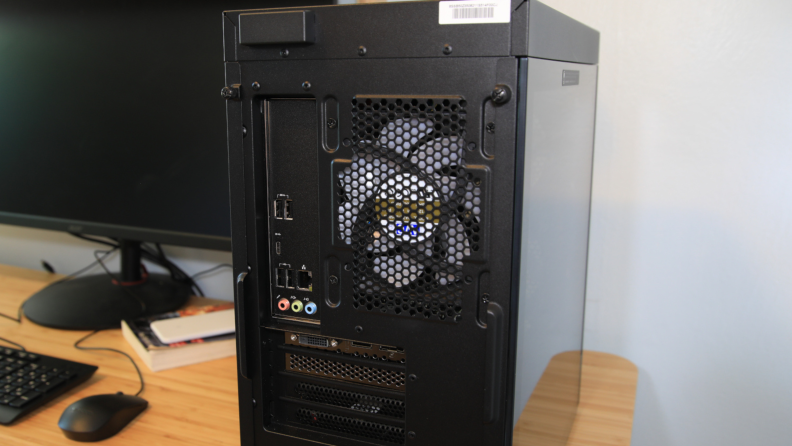A fan inside a desktop computer tower seen through a screen.