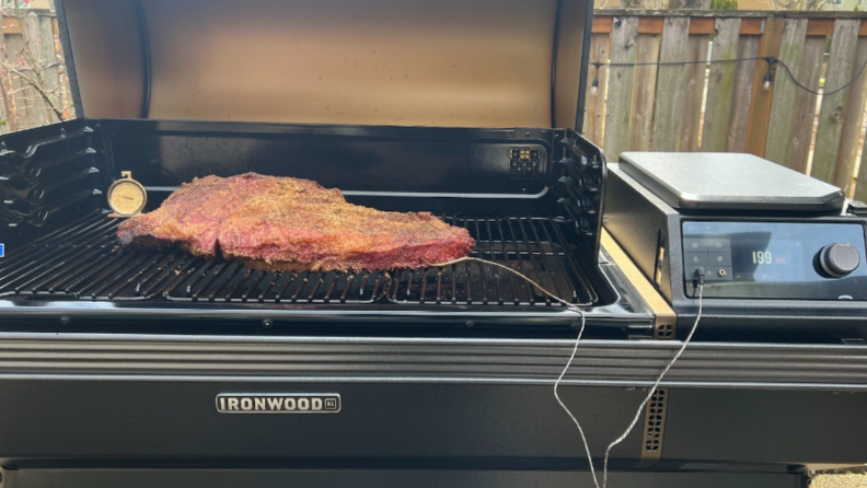 The Traeger Ironwood with a large brisket on the grill, cooking, with the probe in it.