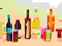 Assorted bottles and cans of various natural wine varietals, featuring brightly-colored labels.
