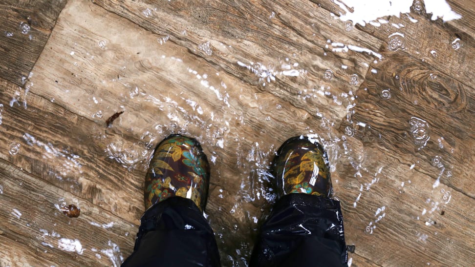 穿着靴子的人站在满是积水的硬木上