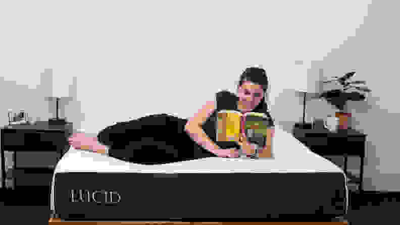 Woman reading a book on the Lucid mattress