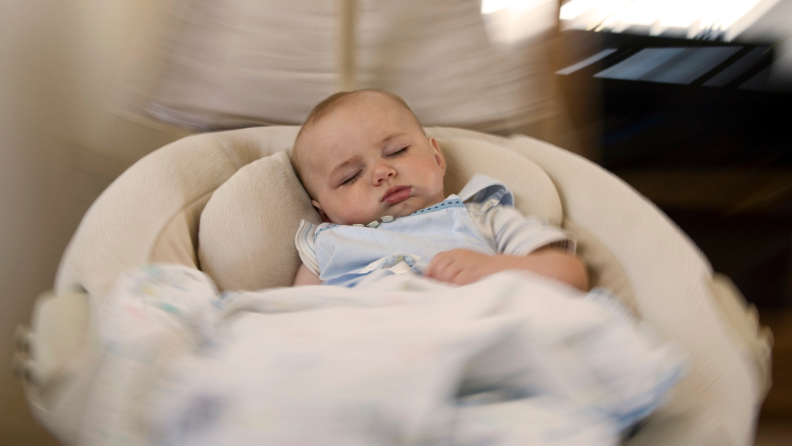 Small baby sleeping in hanging swing.