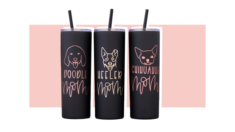 Three black tumblers with a poodle silhouette, a heeler silhouette, and a chihuahua silhouette all against a pink background.