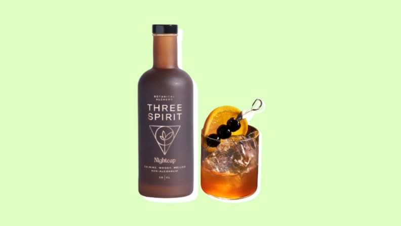 A bottle of Three Spirit's next to a glass of Three Spirit's.