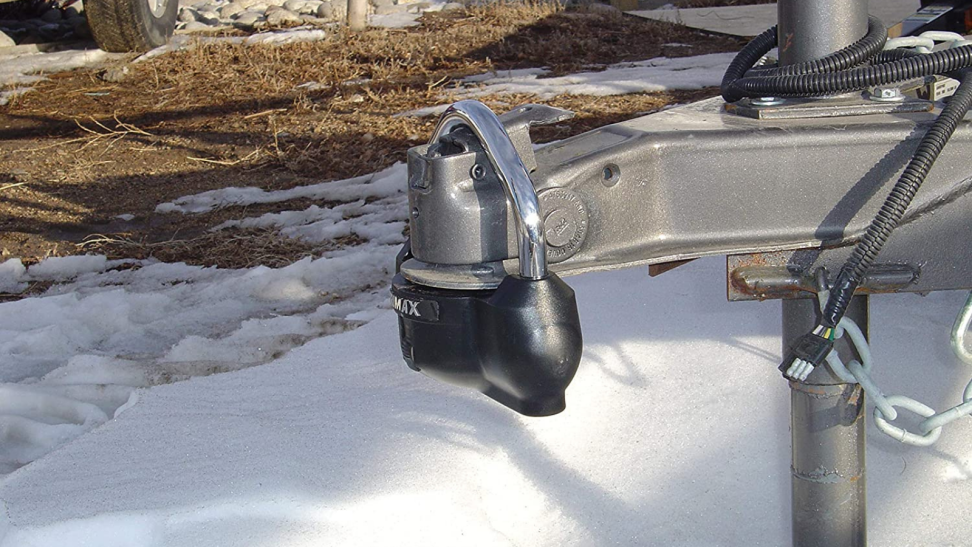 RV hitch lock against a backdrop of snow.