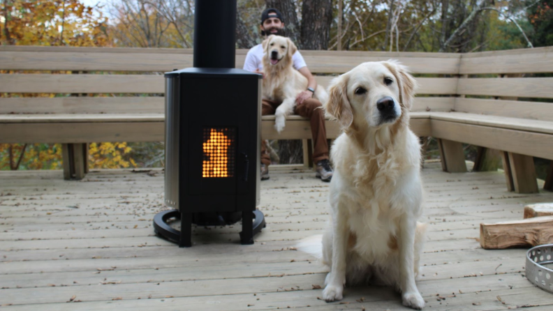 Fire burning inside the Solo Stove Patio Heater with people and dogs sitting around it.