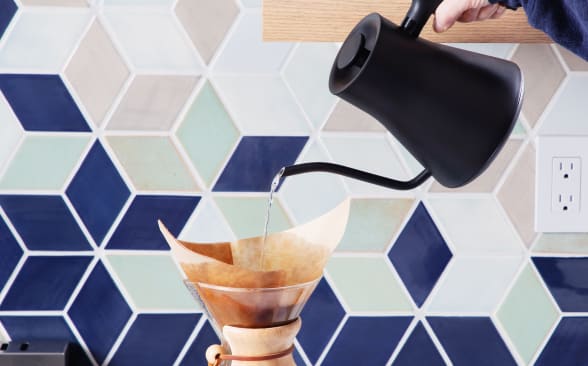 The Fellow Stagg EKG Pro electric kettle pouring water into a Chemex coffee maker.