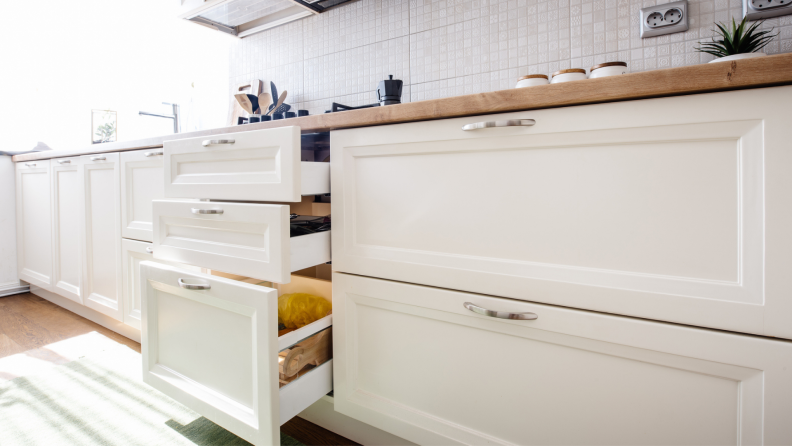 Low white, horizontal cabinet drawers in kitchen.
