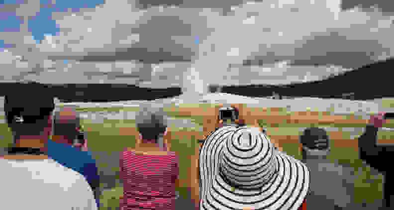 Tourists at Yellowstone's Old Faithful geyser line up to grab the same shot. [Credit: Flickr user 
