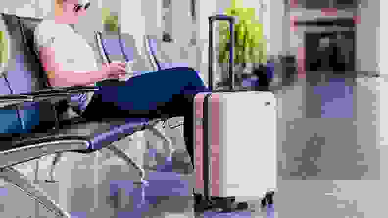 hard shell pink suitcase in airport on granite floor
