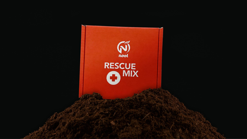 A box of Rescue Mix atop a pile of soil.