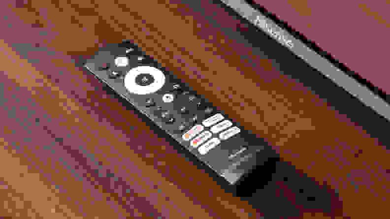 A closeup of the Hisense U7H's remote sitting on a wooden table.