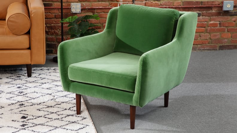 Green Matrix Velvet Chair with wooden legs inside of living room space.