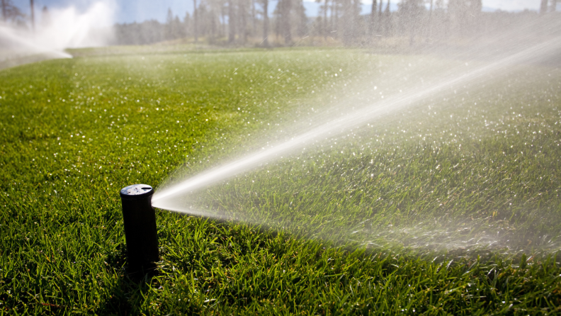 A golf course being watered with underground sprinkler system.