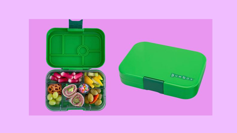 A green Yumbox lunch box on a pink background.