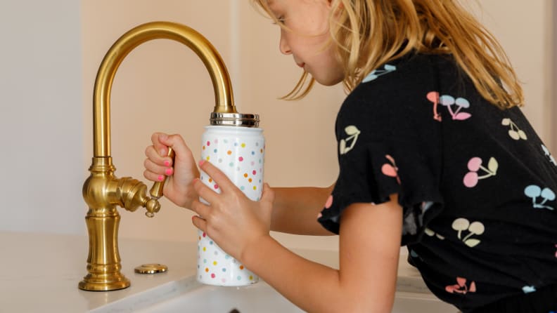 A girl fills her Simple Modern water bottle