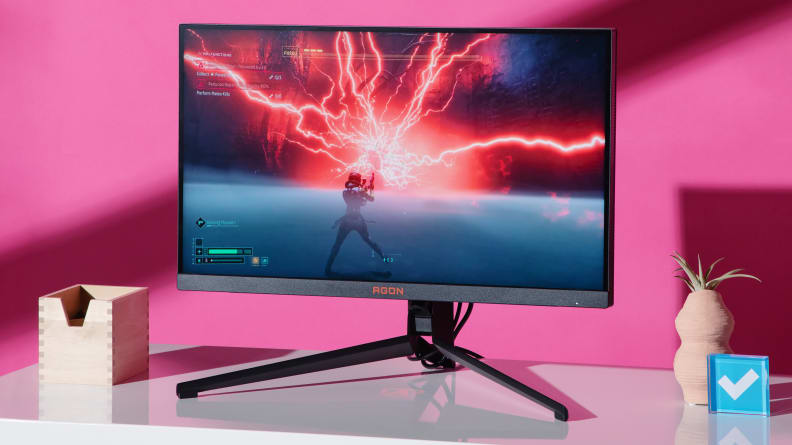 The AGON PRO on a white desktop with a video game on the screen.