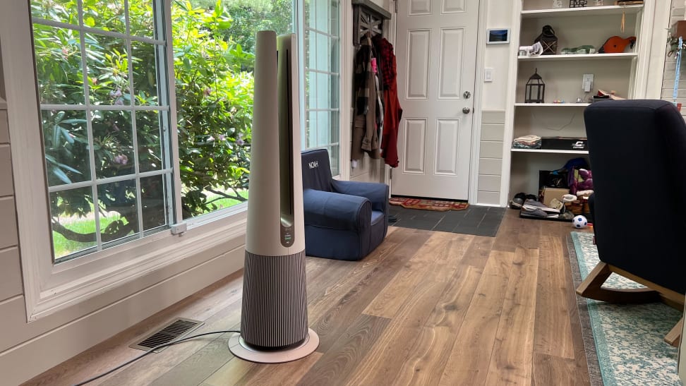 LG AeroTower Air Purifying Fan on top of hardwood floors in front of window inside of home.