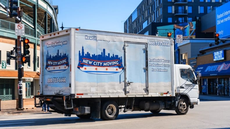 A moving truck on an avenue about to turn left
