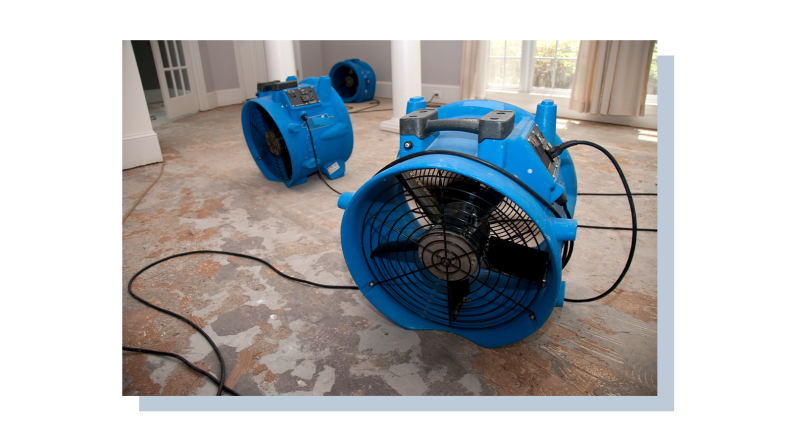 A pair of fans sitting in a dry, untiled floor.