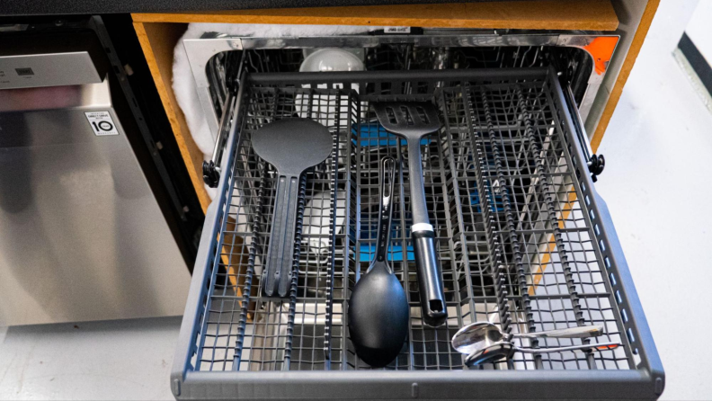 Third rack of a GE dishwasher with spoons and utensils.
