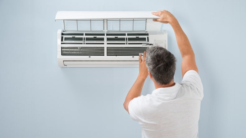 Person opening the air conditioner to fix it.