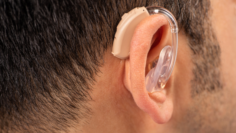 Close-up of a clear hearing aid in an ear