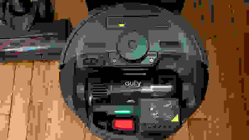 A black robot vacuum on a wood floor