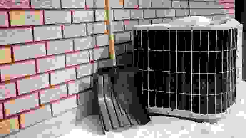 A outdoor air conditioner unit shown outside in the cold snow.