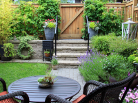 Small outdoor yard space with patio furniture and vibrant flowers.
