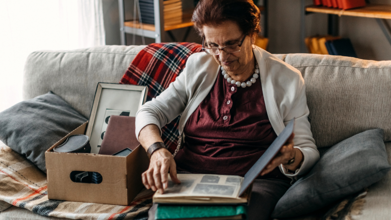 A person looks through a box of memorabilia.