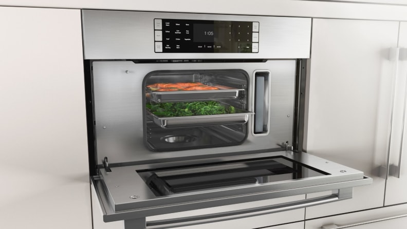 A photo of a steam oven with its door open and food steaming inside.