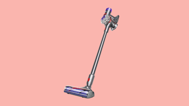 A Dyson V8 Absolute vacuum on a pink background.