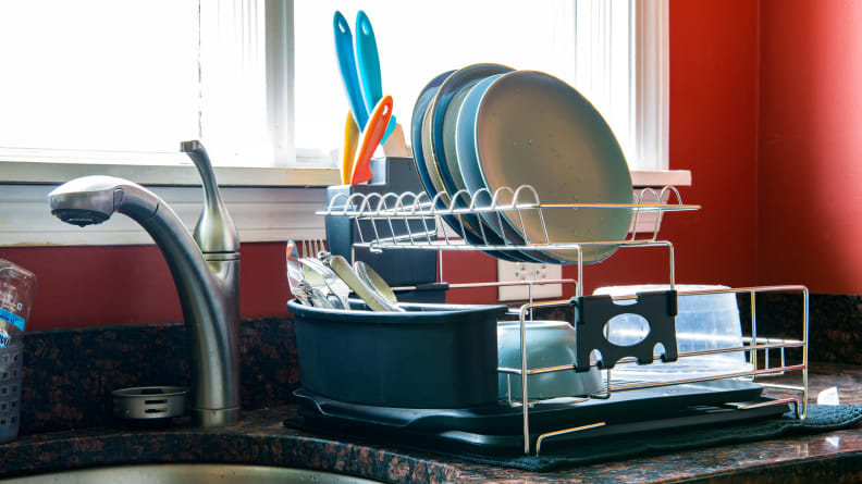 The PremiumRacks dish rack is filled with drying dishes on a kitchen counter.