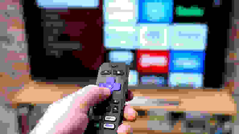 A person holding a remote control for the TCL 8-Series