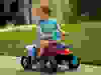 A small child enjoys a ride-on toy from Kid Trax.