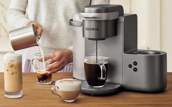 Photo of a model demonstrating a high-end Keurig single-serve coffee maker.