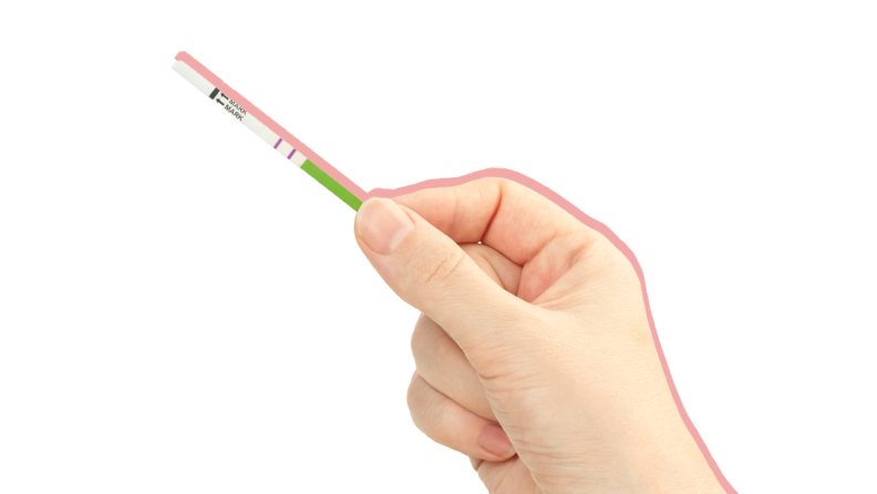 Person holding up ovulation test stick with fingers.