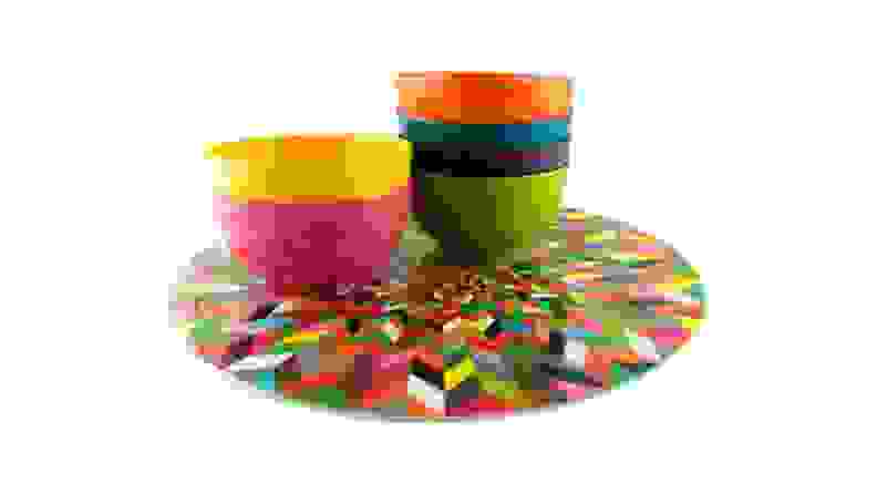 A multicolored Lazy Susan topped with small melamine bowls in assorted colors.