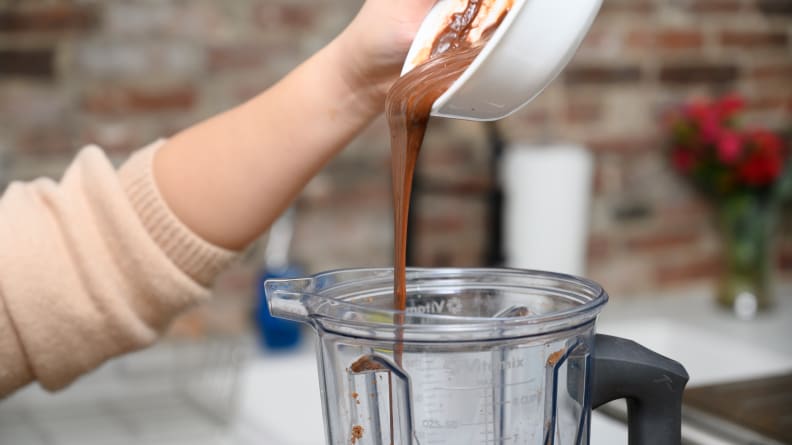 Pour the melted chocolate over the ground hazelnuts to make Nutella