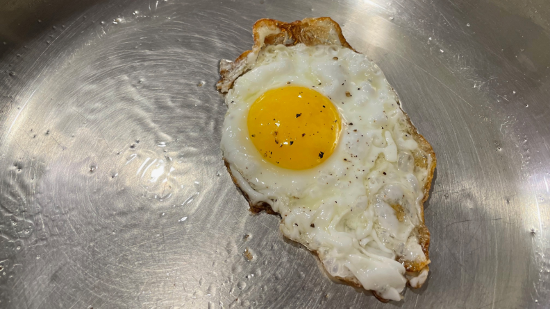 Egg cooking in a stainless steel pan