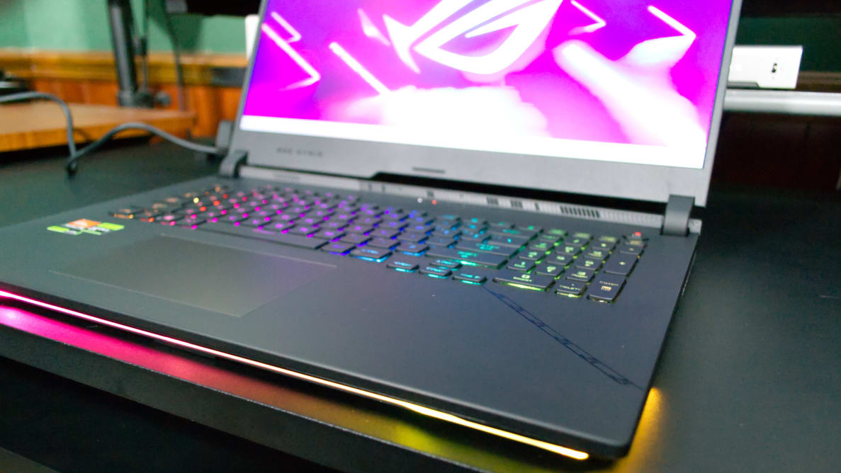 The Asus ROG Strix SCAR 17 (2023) open with a purple screensaver, on a desk