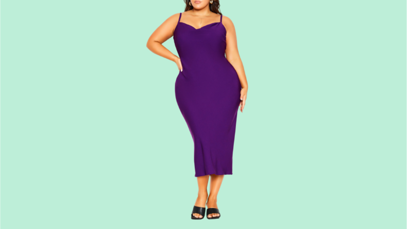 A woman wears a purple slip dress.