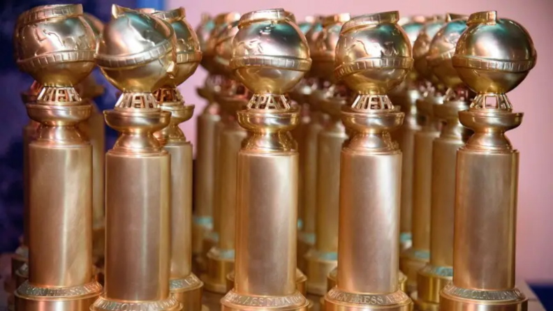 An image of Golden Globe awards in rows on a table.