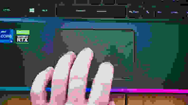 A close up of a hand using the trackpad on a laptop.