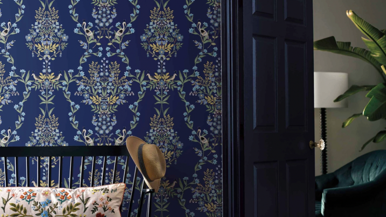 A dark blue wallpaper with a floral design. You can see into a room on the right side of the photo.